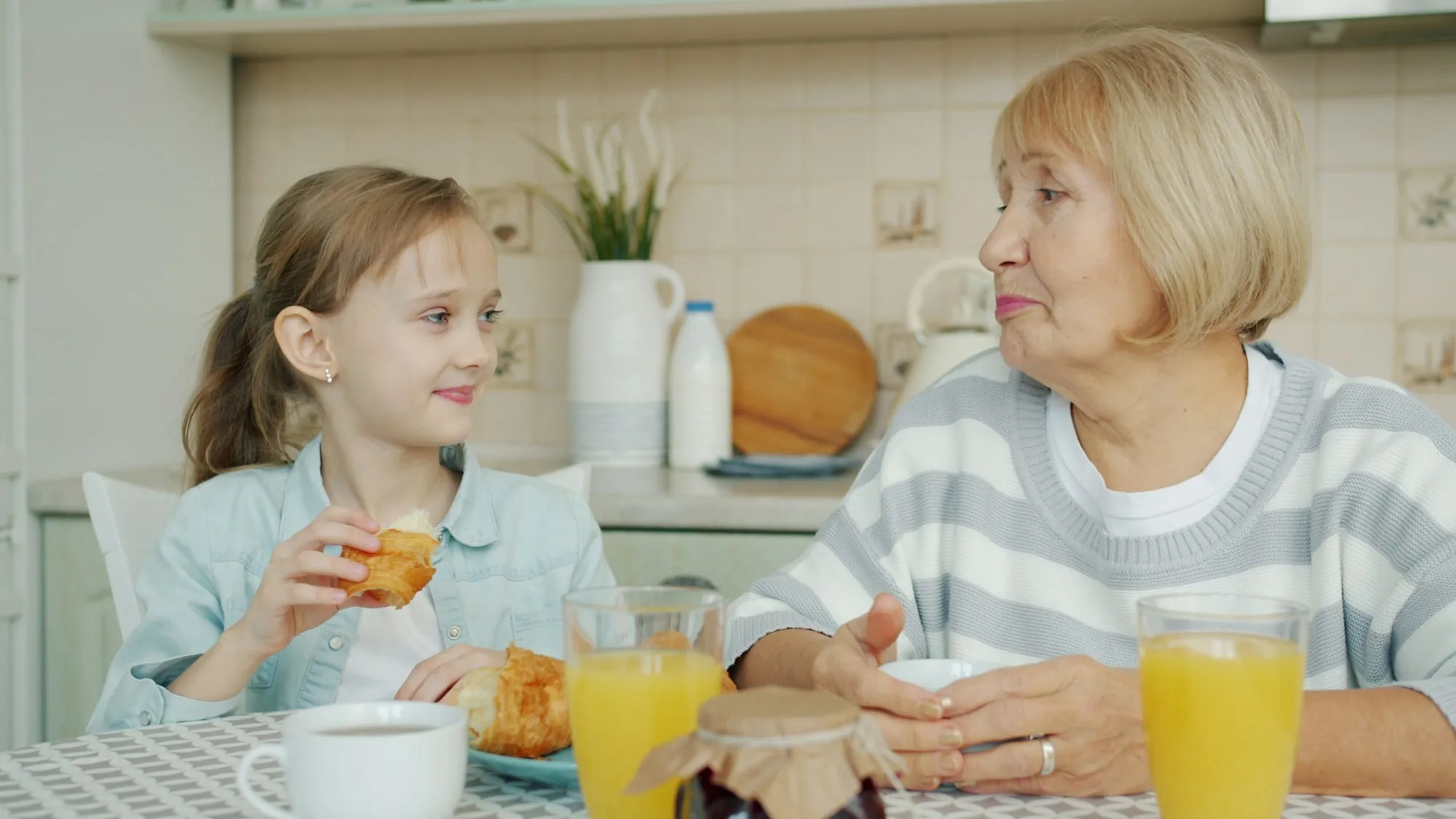 An aide and an older man talking at a kitchen table