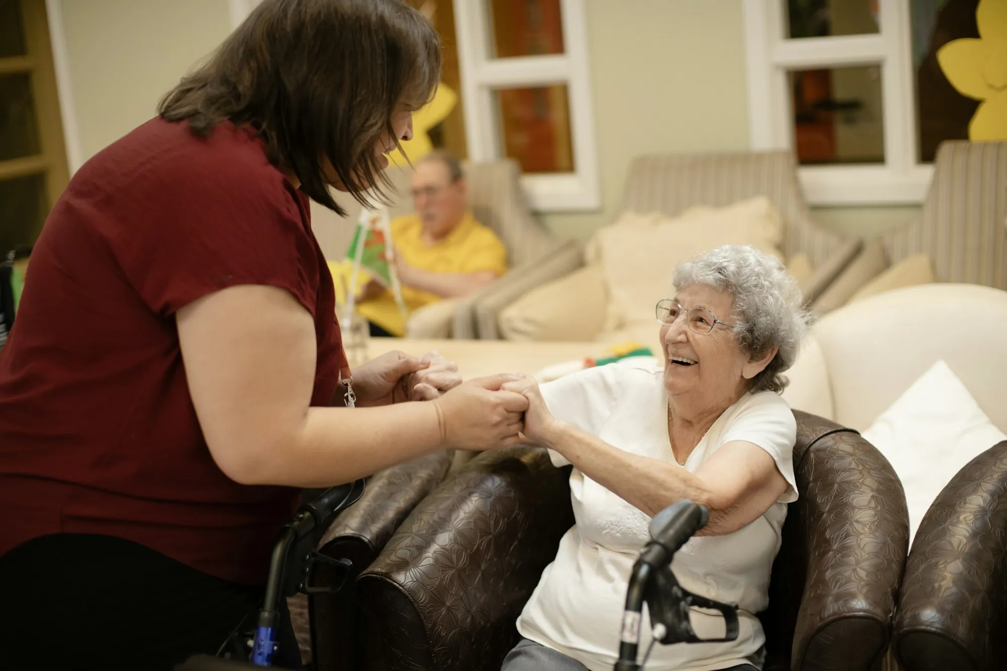 An older woman walking indoors with a frame